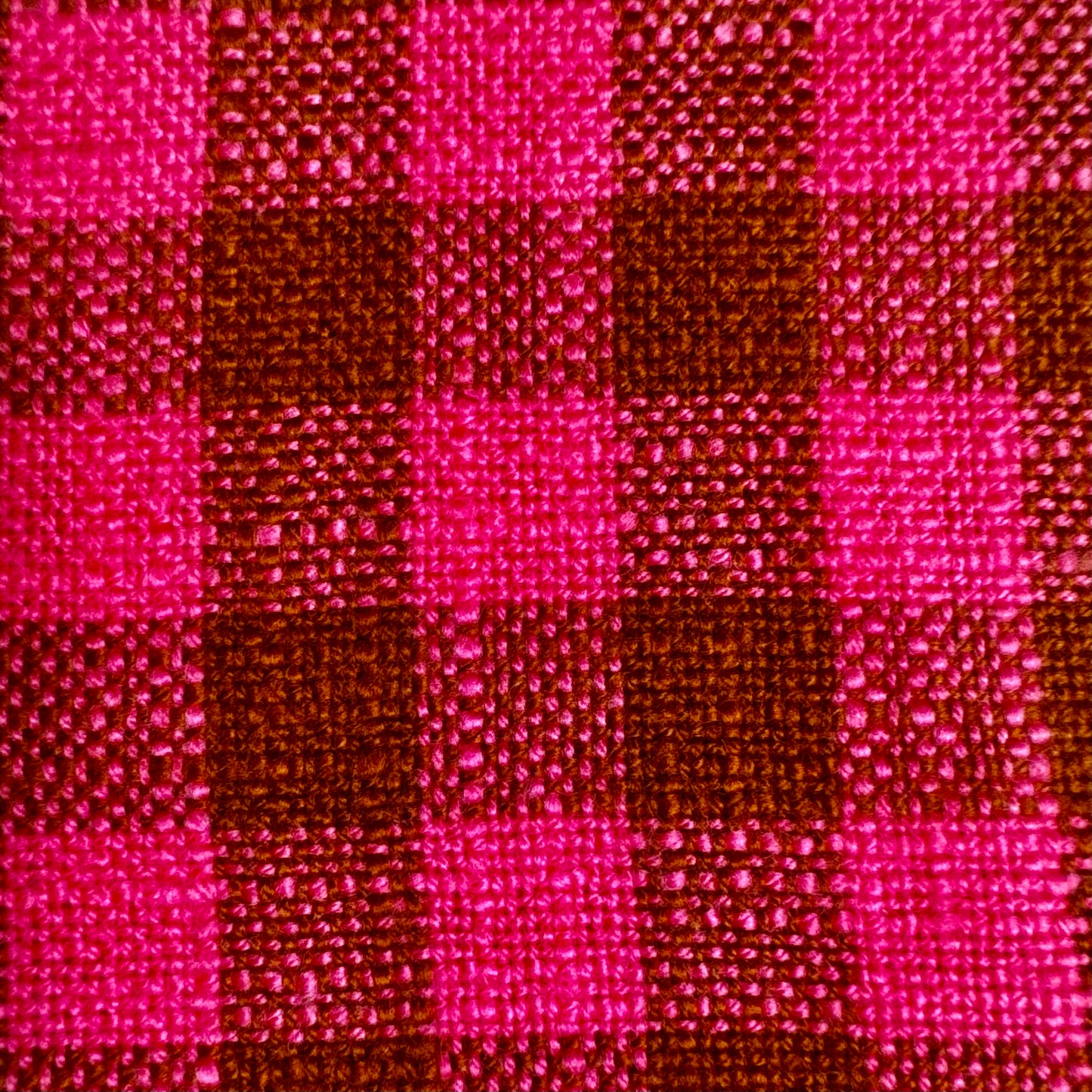 Macro detail of fuchsia and cocoa gingham cotton toweling fabric showing thick slubbed weave