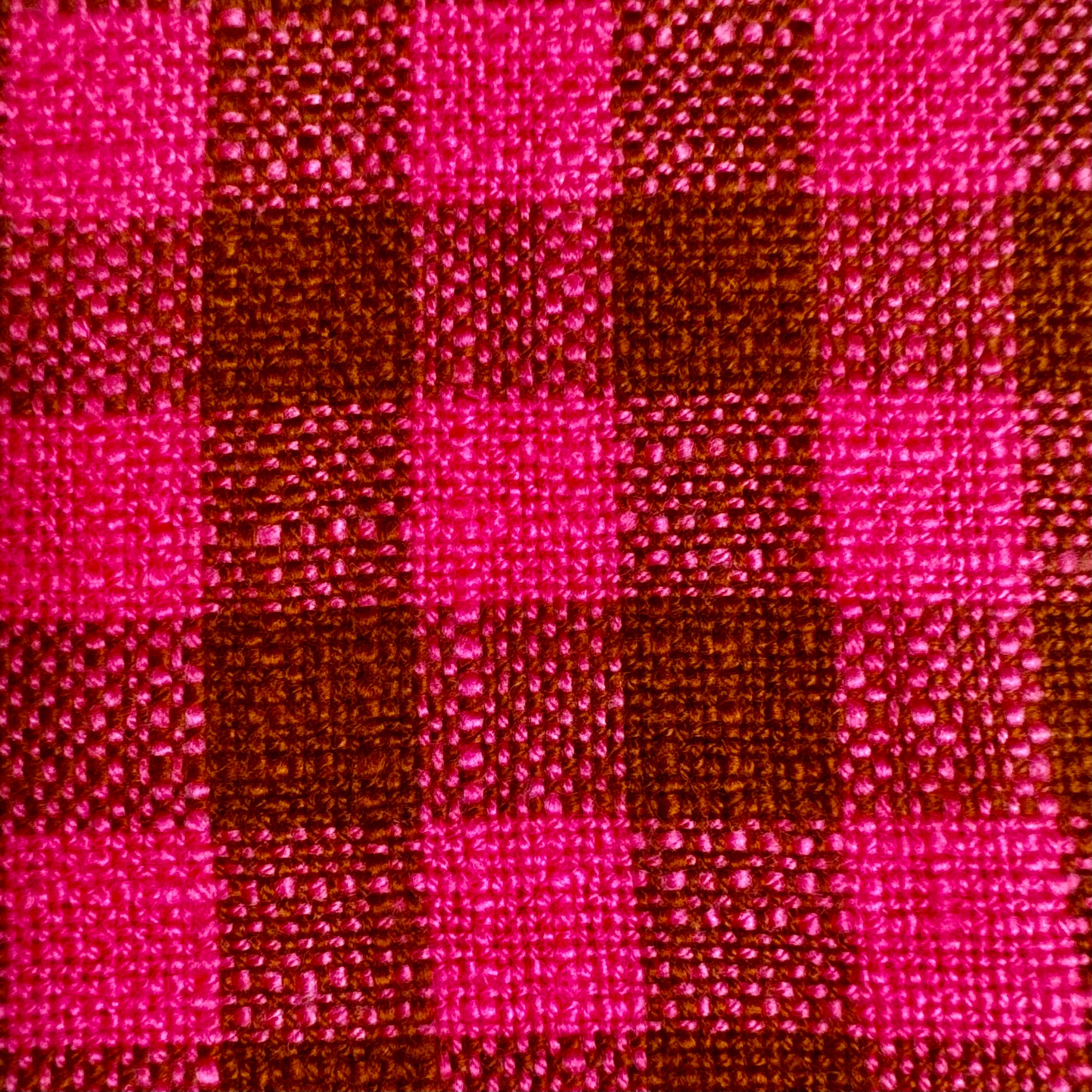 Macro detail of fuchsia and cocoa gingham cotton toweling fabric showing thick slubbed weave