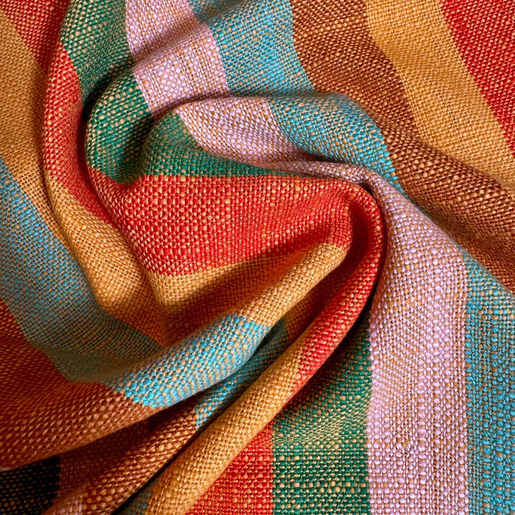Macro detail of multicolor striped cotton toweling fabric folds showing thick slubbed weave
